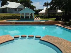 a swimming pool with a gazebo and a house at 9 Montego Bay Caribbean Estates in Port Edward