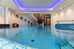 a large swimming pool with a blue ceiling at Vital Hotel Post in Dienten am Hochkönig