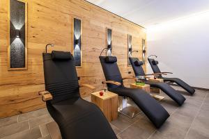 a row of black chairs in a room with wooden walls at Vital Hotel Post in Dienten am Hochkönig