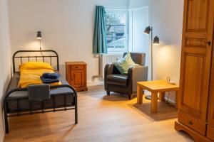 a bedroom with a bed and a chair and a table at Ferienwohnung 'Im Hause Hofland' in Uslar