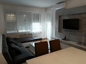 a living room with a couch and a tv at Apartman Vuk in Ćuprija