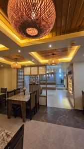 a dining room with a table and chairs and chandeliers at White Dove Luxurious Boutique Hotel, within 3 Km from Guwahati Airport in Guwahati