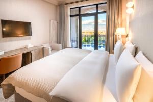 a hotel room with a bed and a desk and a window at Panorama Kakheti Resort in Gurjaani