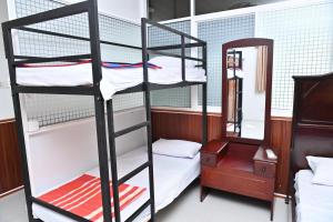a room with two bunk beds and a mirror at Hureshan Villa in Negombo