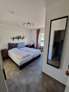 a bedroom with a large bed and a mirror at Galgenberghof Müncheberg in Müncheberg +2 photos