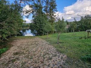 a dirt field next to a river with trees at Galgenberghof Müncheberg in Müncheberg