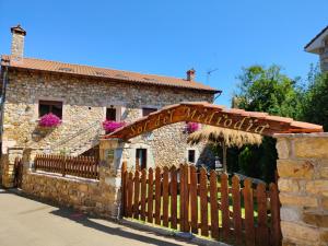 a wooden fence in front of a stone building at Sol del Mediodía in Acebedo +19 photos