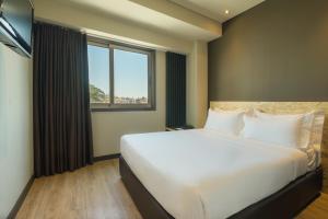 a bedroom with a large white bed and a window at HF Ala Sul in Porto +12 photos