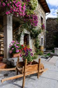 a wooden bench sitting in front of a building with flowers at Sol del Mediodía in Acebedo