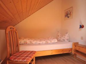 a bed in a room with a wooden chair at Ferienweingut Hammes in Mülheim an der Mosel