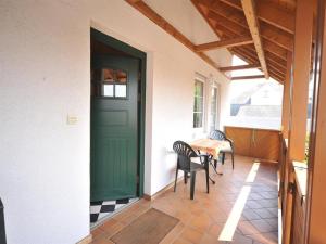 a green door on a porch with chairs and a table at Ferienweingut Hammes in Mülheim an der Mosel +2 photos