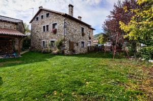 an old stone house with a yard in front of it at Sol del Mediodía in Acebedo