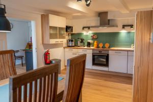 a kitchen with white cabinets and green walls at Ferienwohnung 'Im Hause Hofland' in Uslar