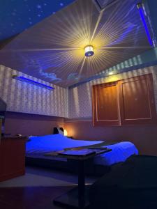 a room with a bed with a light on the ceiling at HOTEL Bew Rose Mary in Kai