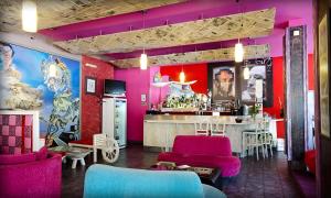 eine Bar in einem Restaurant mit rosa Wänden und Stühlen in der Unterkunft Alliance Hotel in Plowdiw