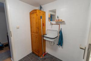 a bathroom with a sink and a wooden cabinet at Ferienwohnung 'Im Hause Hofland' in Uslar +37 photos