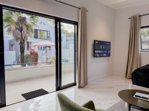 a living room with a view of a palm tree at Amoris Guesthouse I - Randburg in Johannesburg