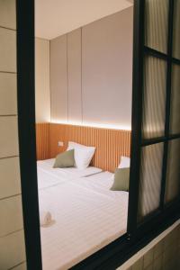 a bedroom with a bed with white sheets and pillows at Liorasuite 4 Bedroom Jacuzzi Billiard Pingpong in KBP in Padalarang