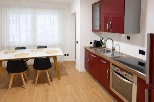 a kitchen with red cabinets and a table and chairs at Comfort Stay Koblenz in Koblenz
