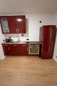 a kitchen with red cabinets and a refrigerator at Comfort Stay Koblenz in Koblenz +2 photos