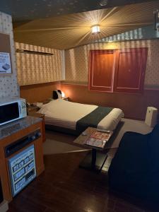 a small bedroom with a bed and a table at HOTEL Bew Rose Mary in Kai +7 photos