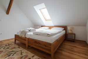 a bedroom with a bed with white sheets and a window at Apartmaji Matec in Fala