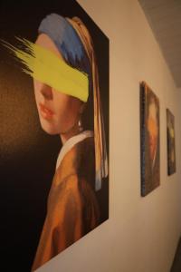 a painting of a woman with a hat on a wall at Villa 18 Hostel in Tirana