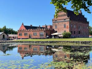 an old castle with its reflection in the water at Broholm Castle in Gudme