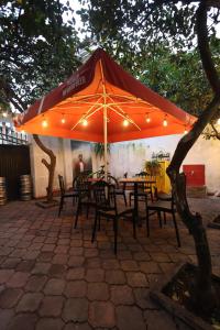 a table and chairs under an orange umbrella at Villa 18 Hostel in Tirana