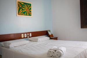 a bed with white sheets and towels on it at Hotel Pousada Dos Ventos in Parnaíba +74 photos