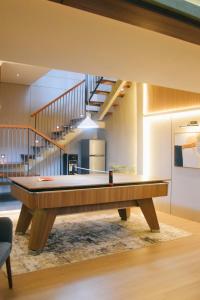 a pool table in a living room with a staircase at Liorasuite 4 Bedroom Jacuzzi Billiard Pingpong in KBP in Padalarang
