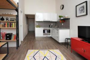 a kitchen with white cabinets and a red table at Urban Jungle in Brno