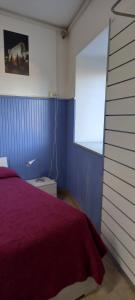 a bedroom with a purple bed and a window at I Love Host 24 in Montefiascone