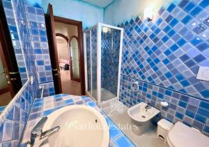 a blue tiled bathroom with a toilet and a sink at Pieno centro con parcheggio - Palau in Palau