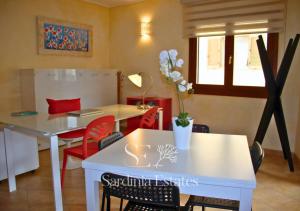 a dining room with a white table and red chairs at Pieno centro con parcheggio - Palau in Palau +41 photos