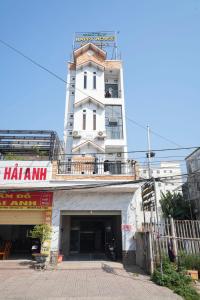 a white building with a balcony on top of it at Nhà Nghỉ Long Nhi in Nhơn Trạch