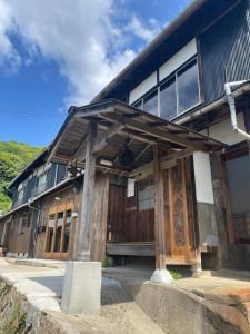 a building with wooden doors and windows on a mountain at HANARE onomichi in Onomichi