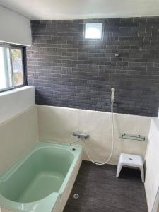 a bathroom with a green bath tub and a stool at HANARE onomichi in Onomichi +6 photos