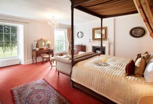 a bedroom with a canopy bed and a desk at Broomfield House in Glasbury