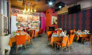 ein Restaurant mit Tischen und Stühlen in einem Raum in der Unterkunft Alliance Hotel in Plowdiw
