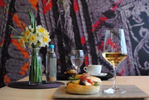 a table with a vase of flowers and wine glasses at Hotel Porta 26 in Skopje +4 photos