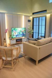 a living room with a couch and a tv at Liorasuite 4 Bedroom Jacuzzi Billiard Pingpong in KBP in Padalarang