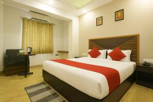 a hotel room with a large bed and a chair at Hotel Grand Delta Near International Airport in New Delhi