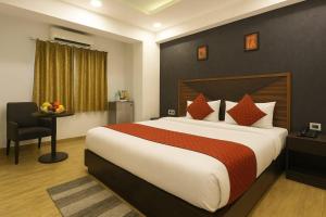 a bedroom with a large bed and a table with a chair at Hotel Grand Delta Near International Airport in New Delhi