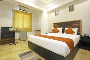a bedroom with a bed and a desk and a chair at Hotel Grand Delta Near International Airport in New Delhi