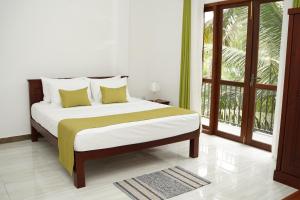 a bedroom with a bed and a large window at Meadow Breeze in Kandy +15 photos