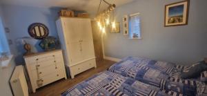 a bedroom with a bed and a dresser and a cabinet at Luxury, Modern Barn Conversion in Thursford
