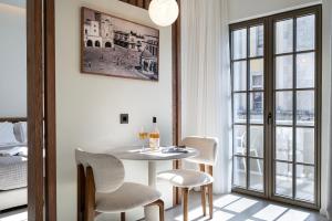 a dining room with a table and chairs and a window at Volaka Luxury Suites in Kos