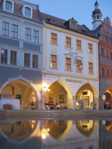 a building with a reflection in a body of water at Gotikhotel Frenzelhof in Görlitz