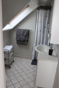 a bathroom with a sink and a shower curtain at 1st floor 2 rooms with kitchenette in Store Heddinge